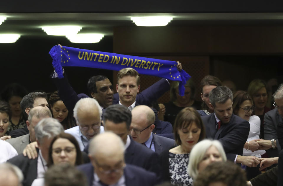 MEP's hold hands and banners after a vote on the UK's withdrawal from the EU, the final legislative step in the Brexit proceedings, during the plenary session at the European Parliament in Brussels, Wednesday, Jan. 29, 2020. The U.K. is due to leave the EU on Friday, Jan. 31, 2020, the first nation in the bloc to do so. (Yves Herman, Pool Photo via AP)