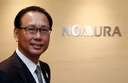 Nomura Holdings president Toshio Morita poses in front of his company's logo prior to an interview with Reuters in Tokyo April 12, 2017. Picture taken on April 12, 2017. REUTERS/Kim Kyung-Hoon