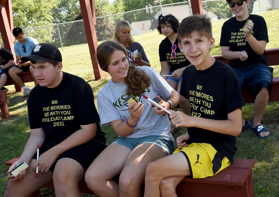 Camper Nick Laroy, 16, (right) with the help of Holiday Camp volunteer Sierra Goins plays the xylophone along with music provided by therapist Kate Holsopple-Stainbrook of Toledo. Also playing is Luke Hill, 13.