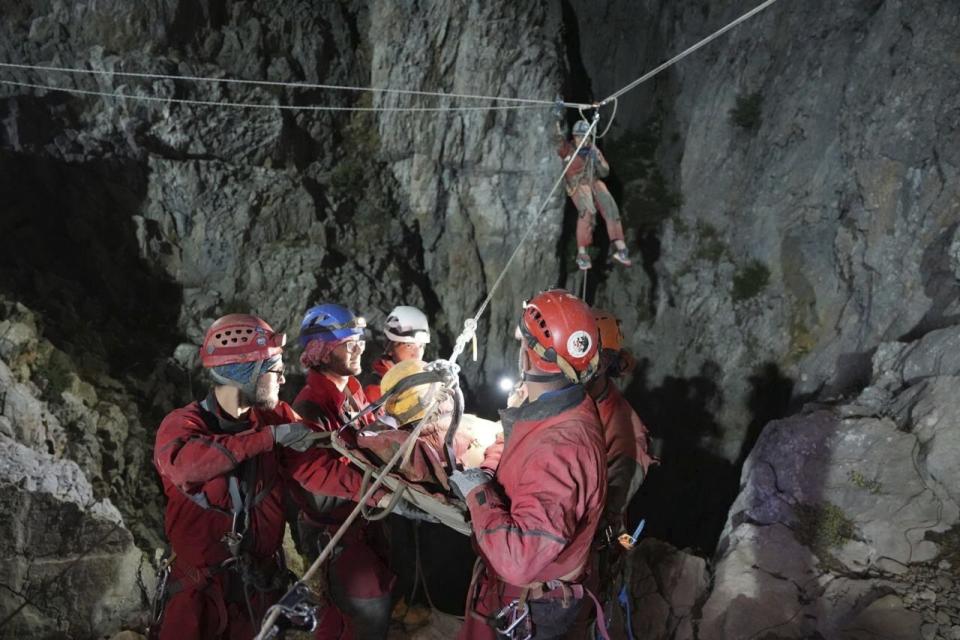 In this photo released by Turkish government's Search and Rescue agency AFAD, American researcher Mark Dickey, center, is pulled out of Morca cave near Anamur, south Turkey, on early Tuesday, Sept. 12, 2023, more than a week after he became seriously ill 1,000 meters (more than 3,000 feet) below its entrance. Teams from across Europe had rushed to Morca cave in southern Turkey's Taurus Mountains to aid Dickey, a 40-year-old experienced caver who became seriously ill on Sept. 2 with stomach bleeding. (AFAD via AP)