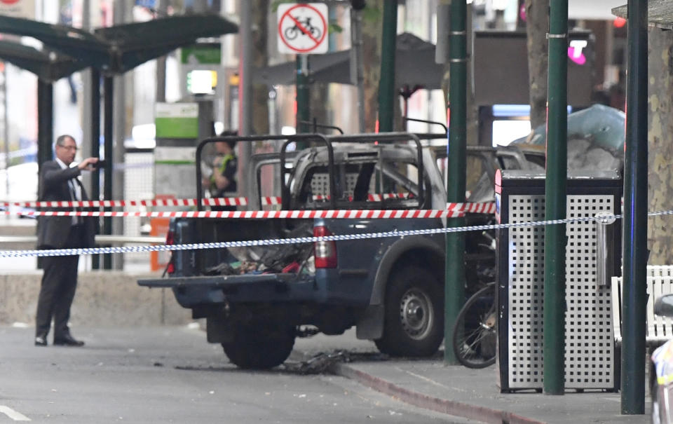 A burnt out vehicle is seen on Bourke Street in Melbourne, Friday, Nov. 9, 2018. A knife-wielding man stabbed two people, one fatally, in Australia's second-largest city on Friday in an attack likely linked to terrorism, police said. The attack during the afternoon rush hour brought central Melbourne to a standstill.(James Ross/AAP Image via AP)