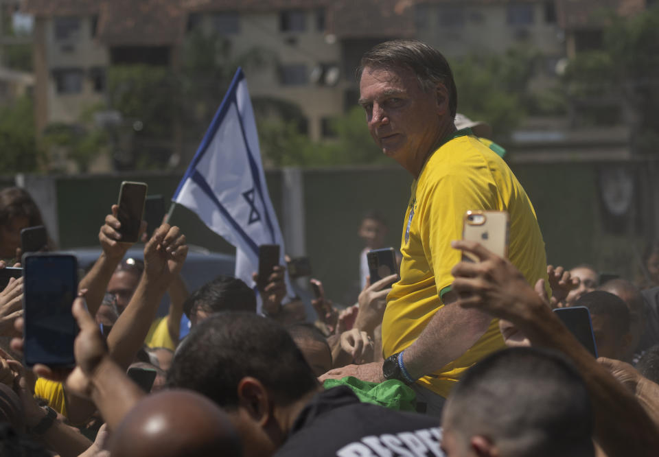 Brazil's former President Jair Bolsonaro is surrounded by supporters after attending a campaign event launching the pre-candidacy of a mayoral candidate, in Rio de Janeiro, Brazil, Saturday, March 16, 2024. (AP Photo/Silvia Izquierdo)