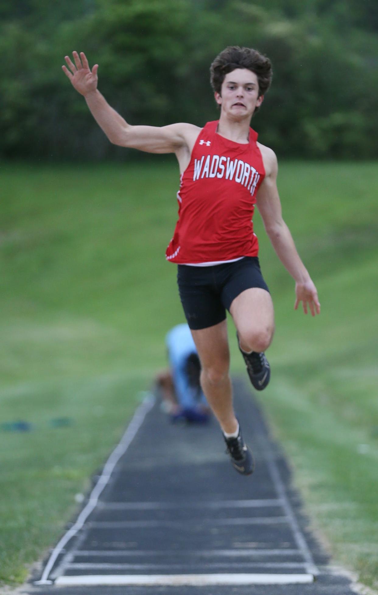 Wadsworth's Will Stack competes in the long jump during the Suburban League National Conference track at Twinsburg High School on Tuesday, May 7, 2024.