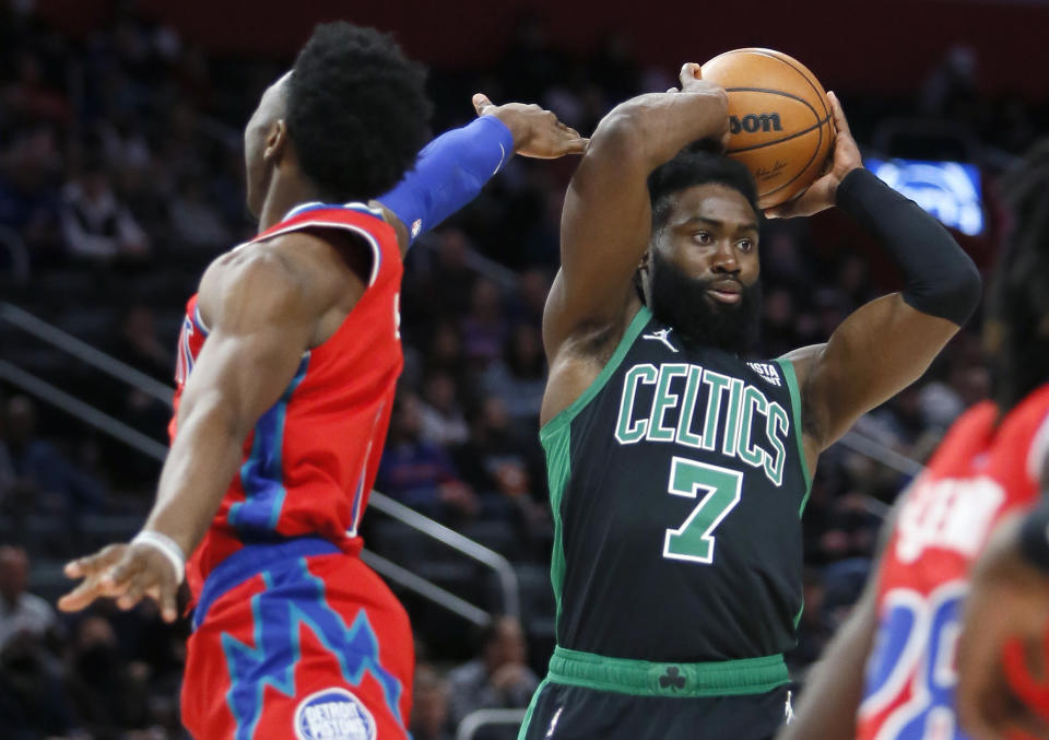 Boston Celtics guard Jaylen Brown (7) passes the ball while being guarded by Detroit Pistons guard Hamidou Diallo, left, during the first half of an NBA basketball game Saturday, Feb. 26, 2022, in Detroit. (AP Photo/Duane Burleson)