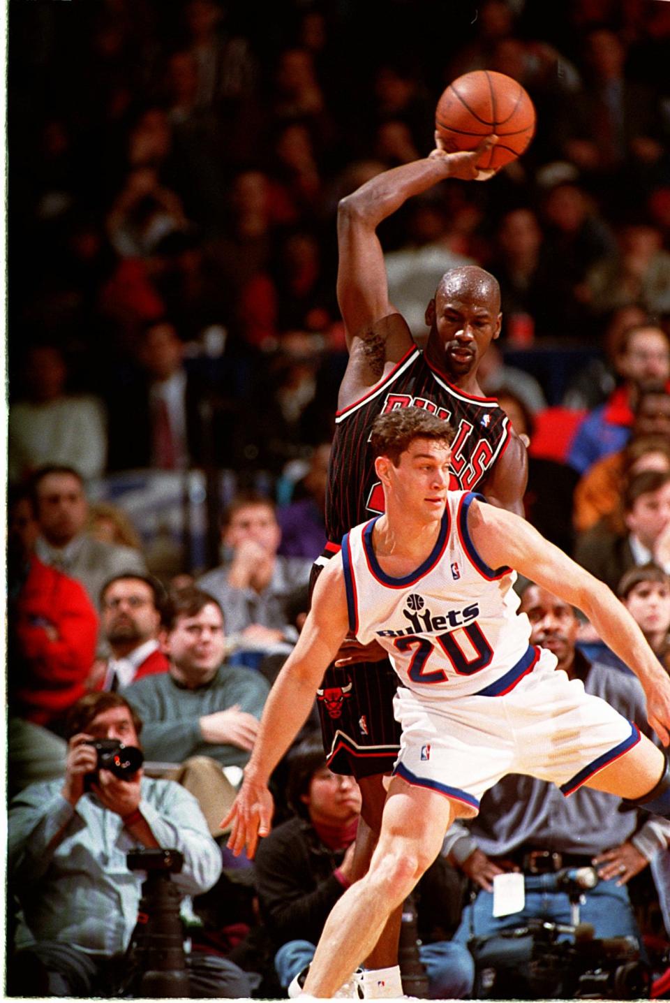 Chicago Bulls guard Michael Jordan (23) goes for the ball over Washington Bullets guard Brent Price (20) on Jan. 29, 1996.