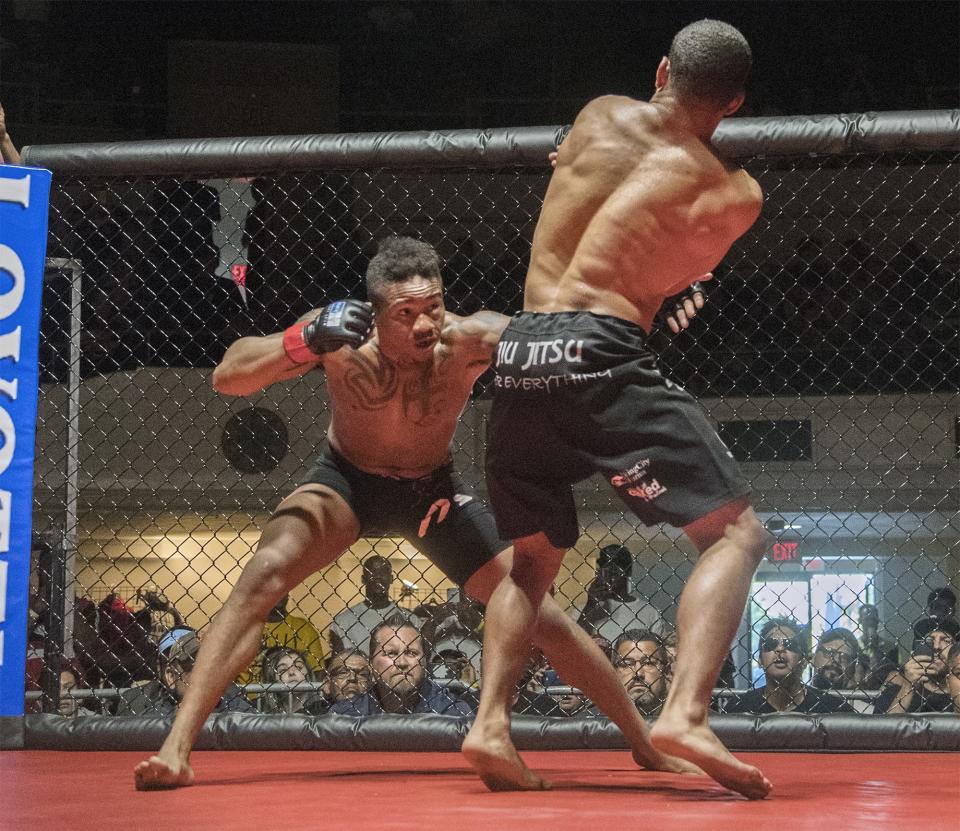 Chris Burton, left, throws a punch against Ernie Juarez in a bout of the 209 Beatdown MMA fights at Stockton Memorial Civic Auditorium. [CLIFFORD OTO/THE RECORD]