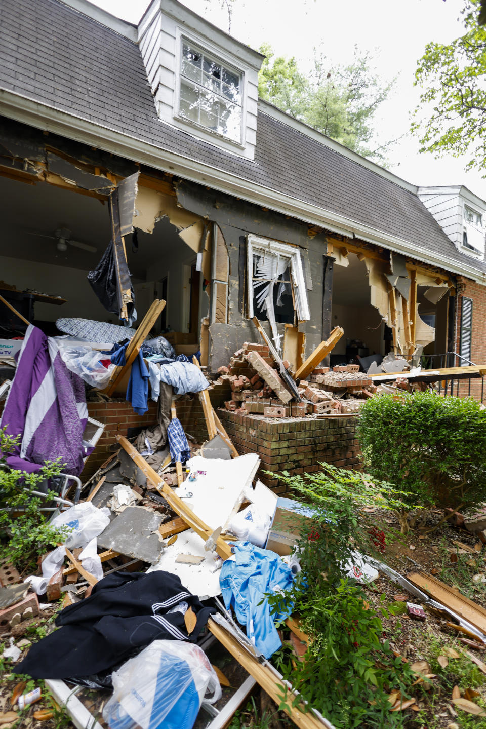 Debris covers a home on Tuesday, April 30, 2024, where a shootout between a suspect and officers occurred on Monday, in Charlotte, N.C. Police say a shootout that killed four law enforcement officers and wounded four others began as officers approached the home to serve a warrant for a felon wanted for possessing a firearm. (AP Photo/Nell Redmond)