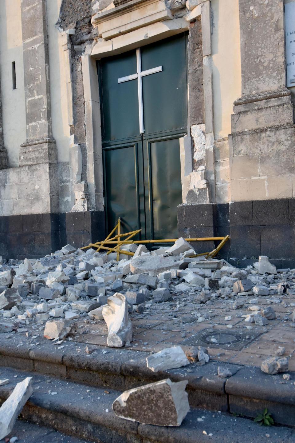 Debris stand in front of the heavily damaged church of Maria Santissima in Fleri, Sicily Italy, Wednesday, Dec. 26, 2018. A quake triggered by Italy's Mount Etna volcano has jolted eastern Sicily, slightly injuring 10 people and prompting frightened Italian villagers to flee their homes. (Orietta Scardino/ANSA Via AP)