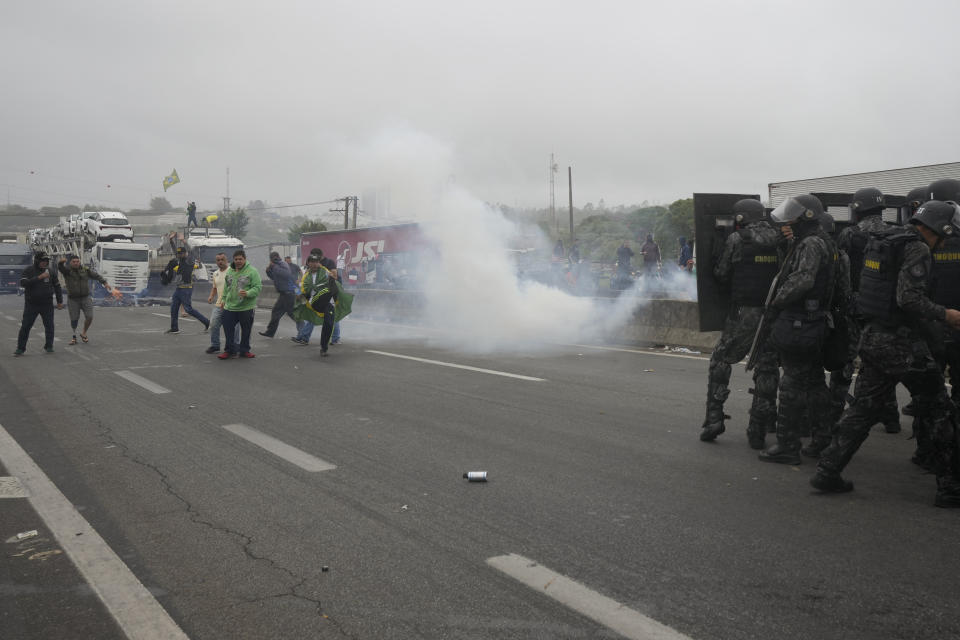 Riot police launch teargas at truckers blocking a highway in protest against President Jair Bolsonaro's loss in the country's presidential runoff election, in Embu das Artes, on the outskirts of Sao Paulo, Brazil, Tuesday, Nov. 1, 2022. Since the former President Luiz Inacio Lula da Silva's victory Sunday night, many truck drivers have jammed traffic in areas across the country and said they won’t acknowledge Bolsonaro’s defeat. Bolsonaro hasn’t spoken publicly since official results were released roughly 36 hours ago, nor phoned da Silva to concede. (AP Photo/Andre Penner)