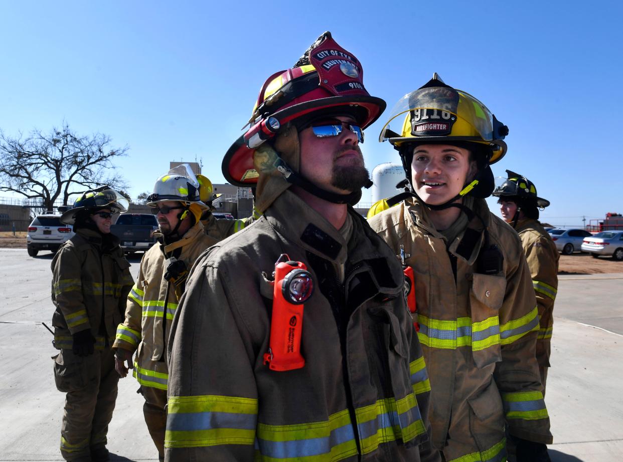 Adison Herd of the Tye Volunteer Fire Department looks to his lieutenant, Briley Snowden, as they prepare to climb the 100-foot ladder on an Abilene fire truck.