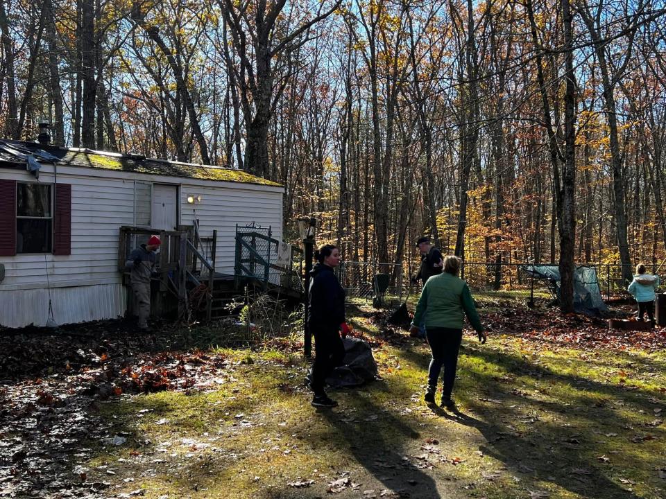 Volunteers from York work to clean up the yard and remove the mold-infested mobile home of Tom Barr, a Vietnam veteran and former Eliot police chief.