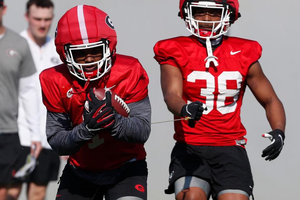 Georgia running back's Trevor Etienne (1) and Brandon Mathis (38) run a drill together during spring practice in Athens, Ga., on Thursday, March 14, 2024.