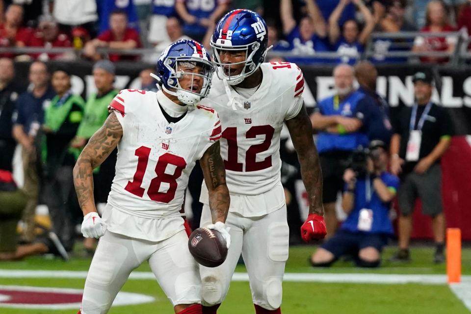 New York Giants tight end Darren Waller (12) celebrates with wide receiver Isaiah Hodgins (18) after Hodgins caught a pass for a touchdown against the Arizona Cardinals during the second half of an NFL football game, Sunday, Sept. 17, 2023, in Glendale, Ariz. (AP Photo/Ross D. Franklin)