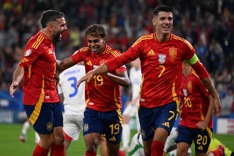 Spain's defender #02 Dani Carvajal (L), Spain's forward #19 Lamine Yamal (2L) and Spain's forward #07 Alvaro Morata (R) celebrate after Italy's defender #05 Riccardo Calafiori scored an own goal during the UEFA Euro 2024 Group B football match between Spain and Italy at the Arena AufSchalke in Gelsenkirchen on June 20, 2024. (Photo by PATRICIA DE MELO MOREIRA / AFP)