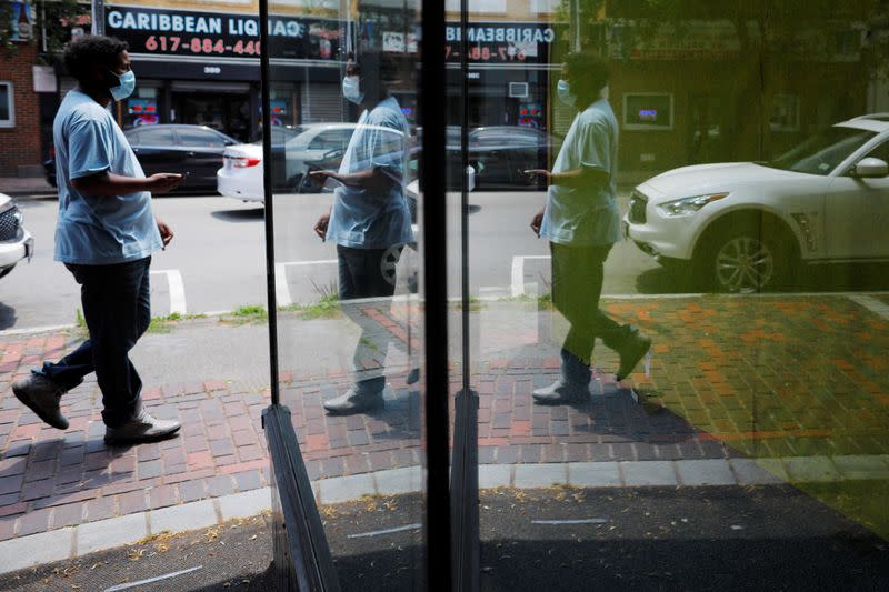 A pedestrian is reflected in the window of an empty storefront in Chelsea