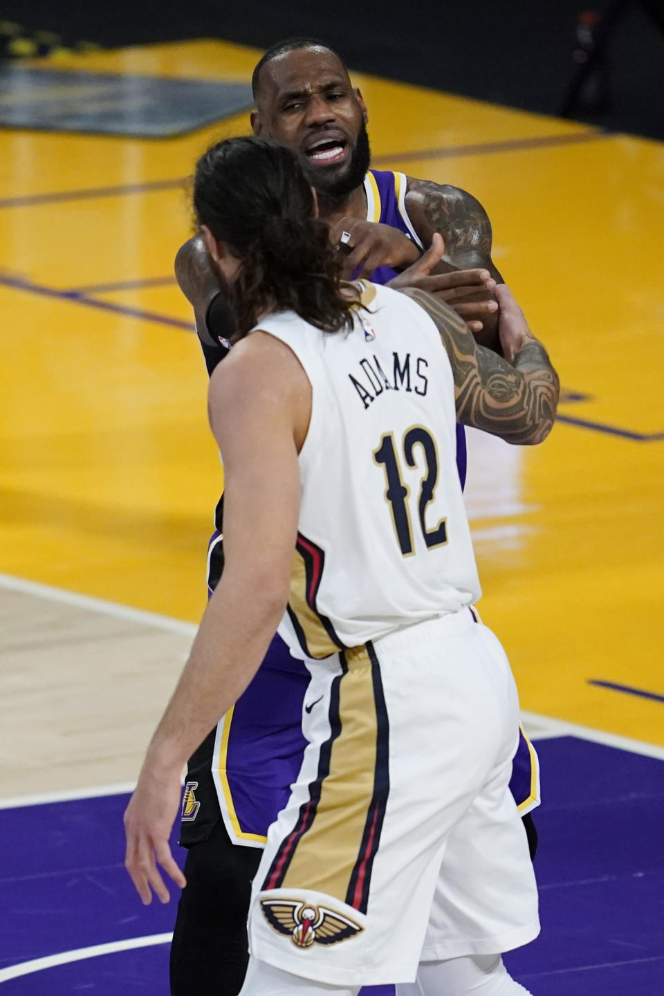 Los Angeles Lakers forward LeBron James, top, and New Orleans Pelicans center Steven Adams (12) air their differences during the second quarter of an NBA basketball game Friday, Jan. 15, 2021, in Los Angeles. (AP Photo/Ashley Landis)