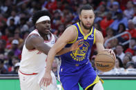 Golden State Warriors guard Stephen Curry, right, drives to the basket as Houston Rockets guard Aaron Holiday, left, reaches in during the second half of an NBA basketball game Thursday, April 4, 2024, in Houston. (AP Photo/Michael Wyke)