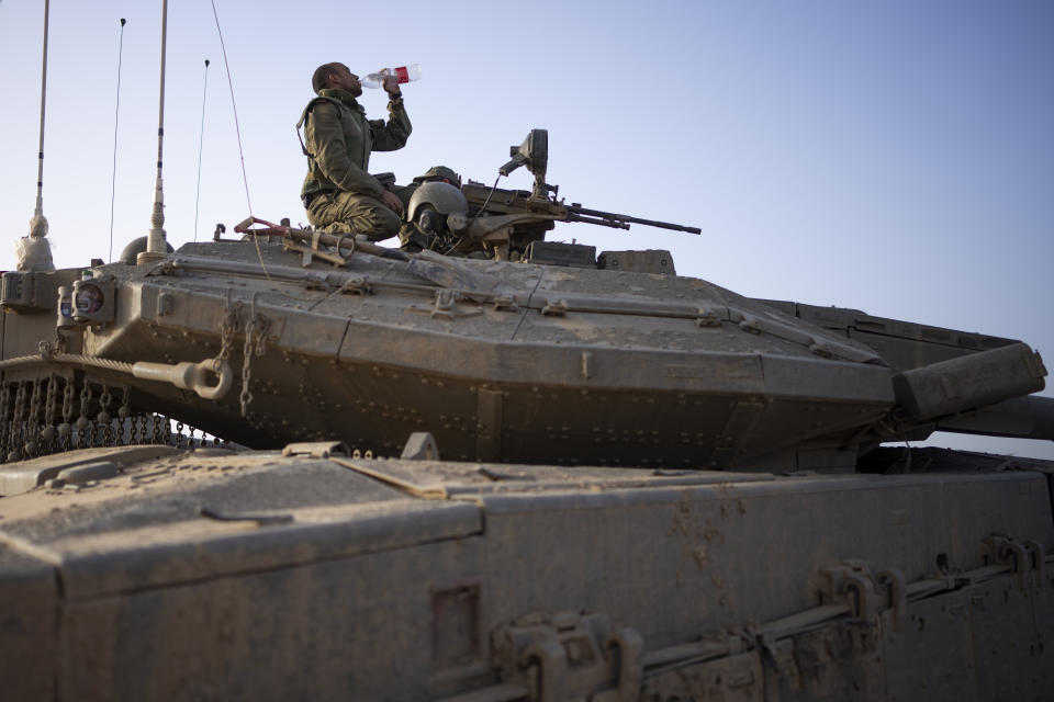 A soldier who just arrived from deployment in the Gaza Strip drinks water at an army staging area in southern Israel, Sunday, Nov. 26, 2023. (AP Photo/Victor R. Caivano)