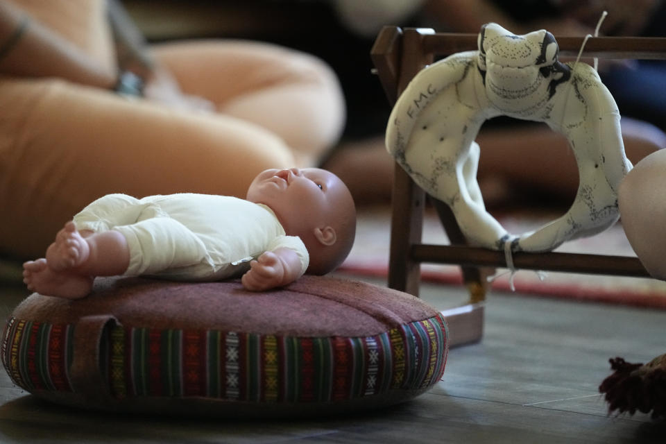 A doll and a model of the birthing canal is seen during a prenatal group meeting at The Farm Midwifery Center, Thursday, Aug. 31, 2023, in Summertown, Tenn. The Farm said fewer than 2% of clients end up having C-sections, and a report on deliveries in its first 40 years showed 5% of clients were transported to the hospital — which midwife Corina Fitch said can happen because of things like water breaking early or exhaustion during labor. Clients usually give birth at The Farm or in their own homes. (AP Photo/George Walker IV)