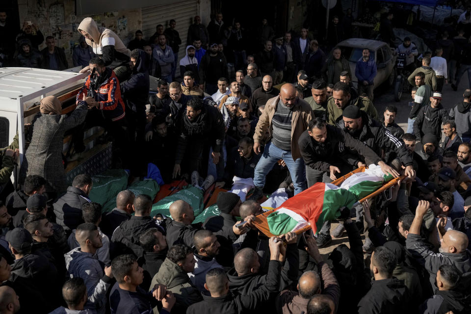 Mourners carry the bodies of six Palestinians, some are draped in the Hamas flags during their funeral in the West Bank city of Jenin on Sunday, Jan. 7, 2024. Six Palestinians and a member of Israel's paramilitary border police were killed in confrontations in a hot spot of violence in the Israeli-occupied West Bank, the Palestinian Health Ministry and the Israeli military said Sunday. (AP Photo/Majdi Mohammed)