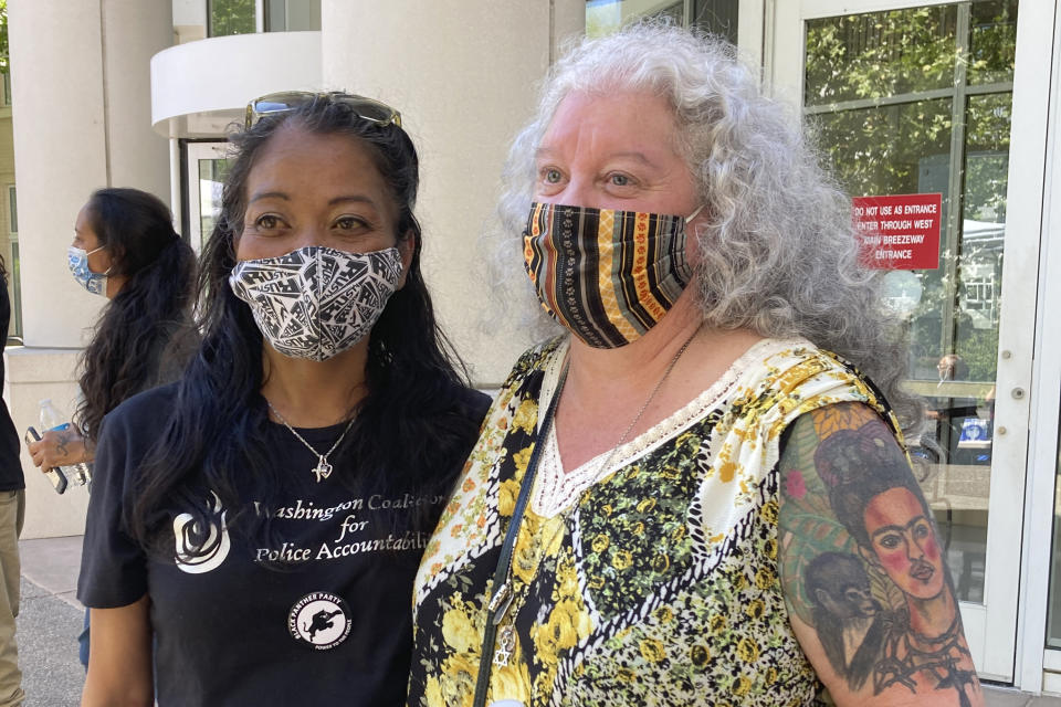 Kari Sarey, left, the mother of Jesse Sarey — who was killed by Auburn police Officer Jeff Nelson in 2019 — stands with Elaine Simons, who briefly fostered Jesse Sarey when he was young, Thursday, June 3, 2021, outside the Maleng Regional Justice Center in Kent, Wash. Nelson has been charged in the shooting, and has been investigated in more than 60 use-of-force cases since 2012, but he wasn't on the King County prosecuting attorney's "potential impeachment disclosure" list, or Brady List, which flags officers whose credibility is in question due to misconduct, until after being charge in Sarey's death. (AP Photo/Martha Bellisle)