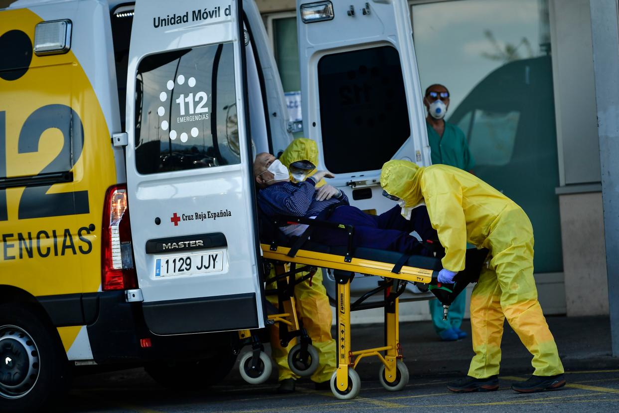 Ambulance employees wear special equipment to prevent the spread of coronavirus COVID-19 arriving with a patient at San Pedro hospital, in Logrono, northern Spain, on Saturday, March 28, 2020.