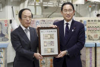 Japanese Prime Minister Fumio Kishida, right, and Bank of Japan Governor Kazuo Ueda hold the country’s new banknotes in a frame, during a ceremony to mark the release of the banknotes, at the BOJ headquarters in Tokyo, Japan, Wednesday, July 3, 2024. (Japan Pool/Kyodo News via AP)