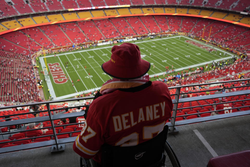 Seorang penggemar menyaksikan pemanasan di Stadion Arrowhead menjelang badai yang menunda pertandingan. (Foto AP/Charlie Riedel)