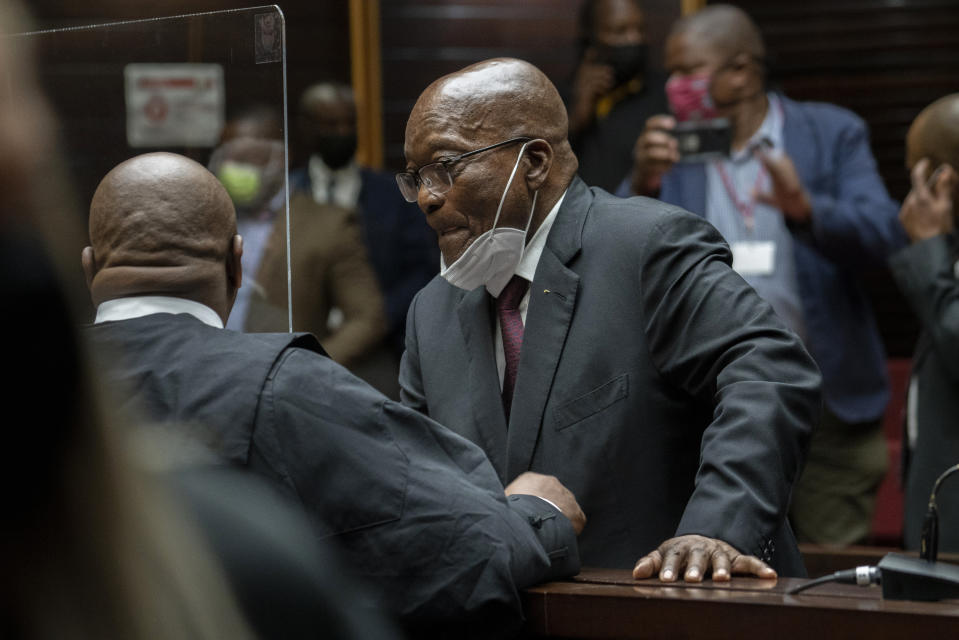 Former South African President Jacob Zuma, speaks with his legal counsel during a recess in the High Court in Pietermaritzburg, South Africa, Tuesday Oct. 26, 2021. Zuma has demanded to be acquitted of corruption charges because of the alleged abuse he has suffered at the hands of his prosecutors. He is in court facing charges of corruption, money laundering and racketeering. (AP Photo/Jerome Delay, Pool)