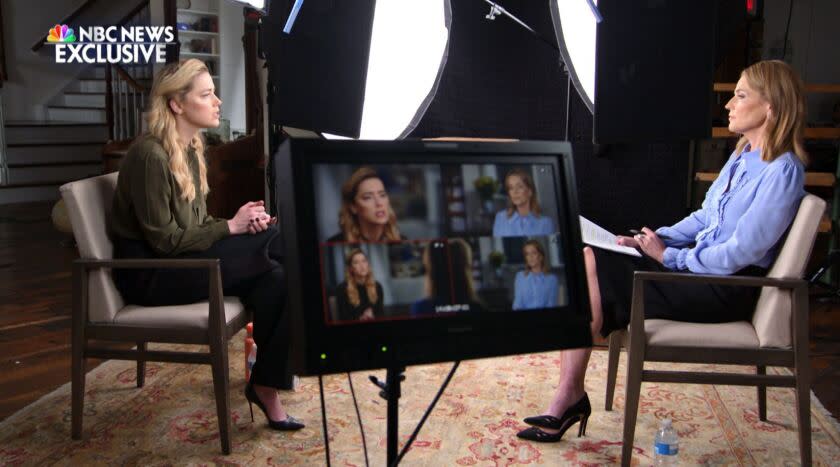 A female actor and a female journalist sit amid lights and a TV monitor for a broadcast interview