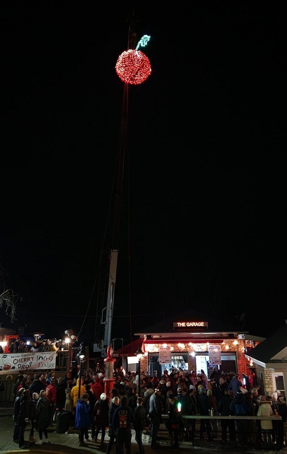 The 300-pound metal cherry hovers over downtown Sister Bay before it begins its descent to count down to the New Year at the 2022 The Lodge Cherry Drop. The annual event again takes place the evening of Dec. 31, along with fireworks and other activities.