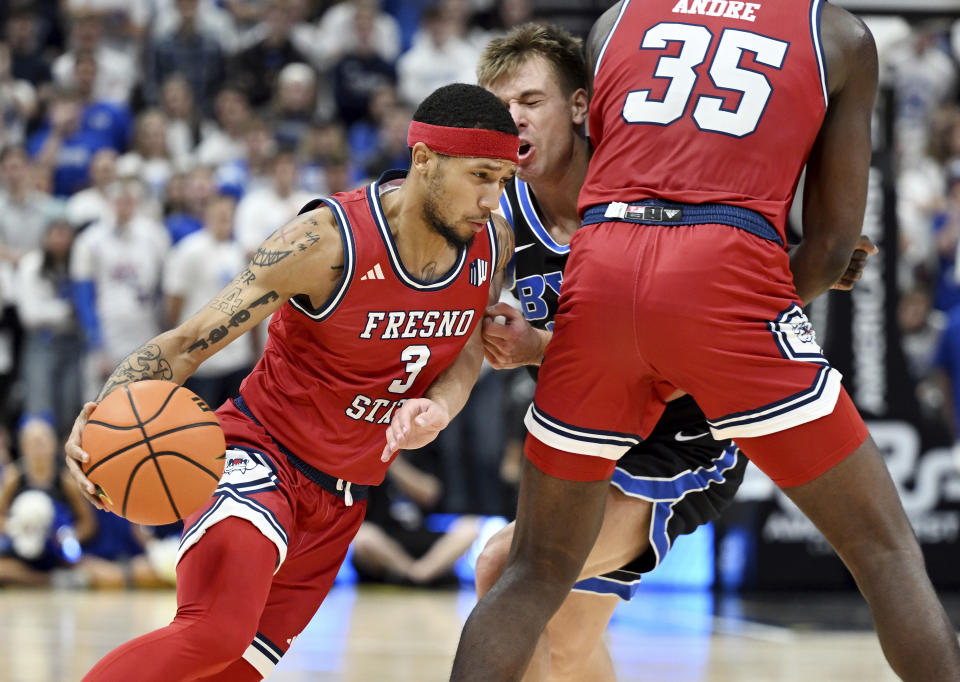 Fresno State guard Isaiah Hill (3) uses a screen by center Eduardo Andre (35) to shed BYU guard Dallin Hall, center, during an NCAA college basketball game in Salt Lake City, Friday, Dec. 1, 2023. (Scott G Winterton/The Deseret News via AP)