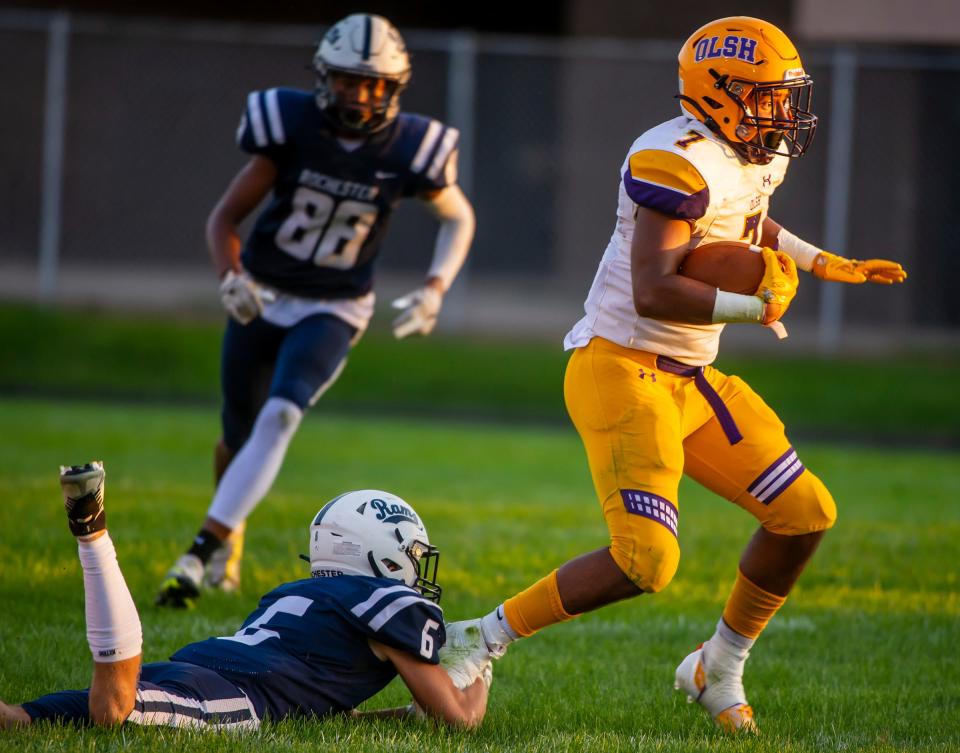Rochester's DJ Smith grabs the foot of OLSH's Dereon Greer during their game Friday night at Rochester High School. [Lucy Schaly/For BCT]