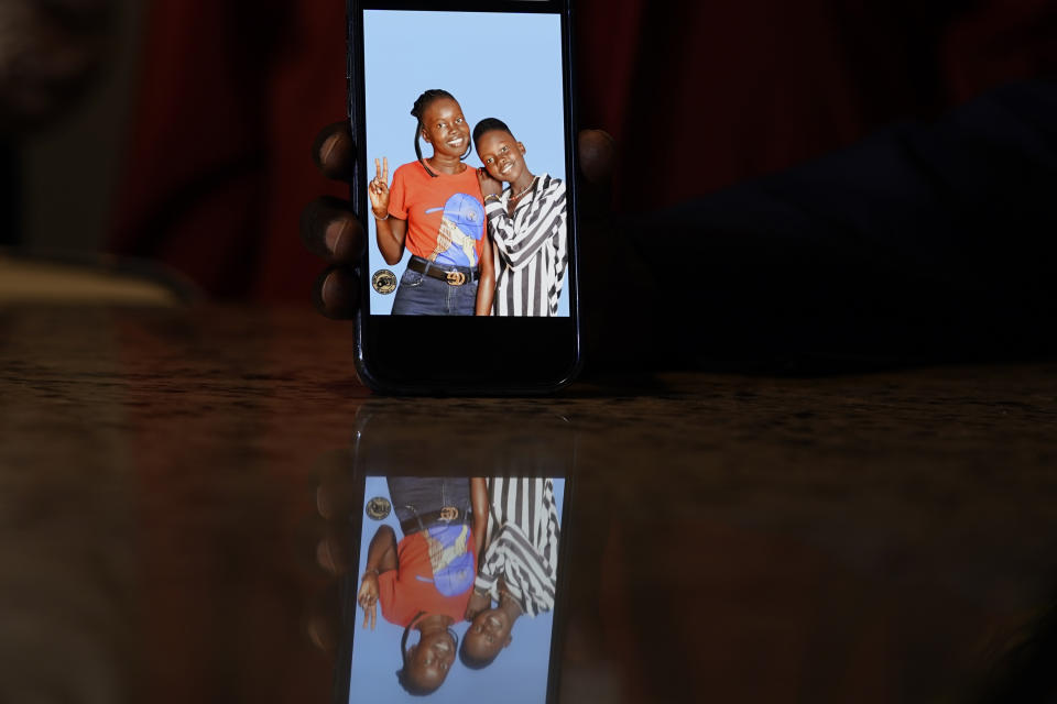 Jacob Mabil shows a cell phone photo of hie nieces Nyanluak Deng, left, and Anyier Deng during an interview at his home Wednesday, Nov. 8, 2023, in Haslet, Texas. (AP Photo/LM Otero)