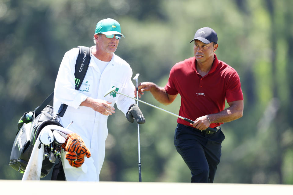 AUGUSTA, GEORGIA - APRIL 14: Tiger Woods of the United States exchanges clubs with caddie Lance Bennett on the 18th green during the final round of the 2024 Masters Tournament at Augusta National Golf Club on April 14, 2024 in Augusta, Georgia. (Photo by Andrew Redington/Getty Images)