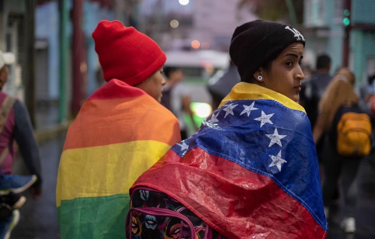 A Venezuelan migrant wears their national flag within a group of migrants leaving Tapachula by foot in Chiapas state, Mexico on June 6, 2022.