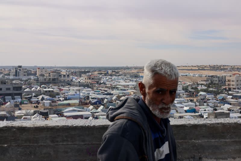 Displaced Palestinians, who fled their houses due to Israeli strikes, take shelter in a tent camp, in Rafah