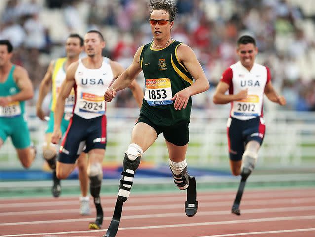 <p>Phil Cole/Getty </p> Oscar Pistorius of South Africa wins the 200m T44 for Men at the Athens 2004 Paralympic Games on September 21, 2004.