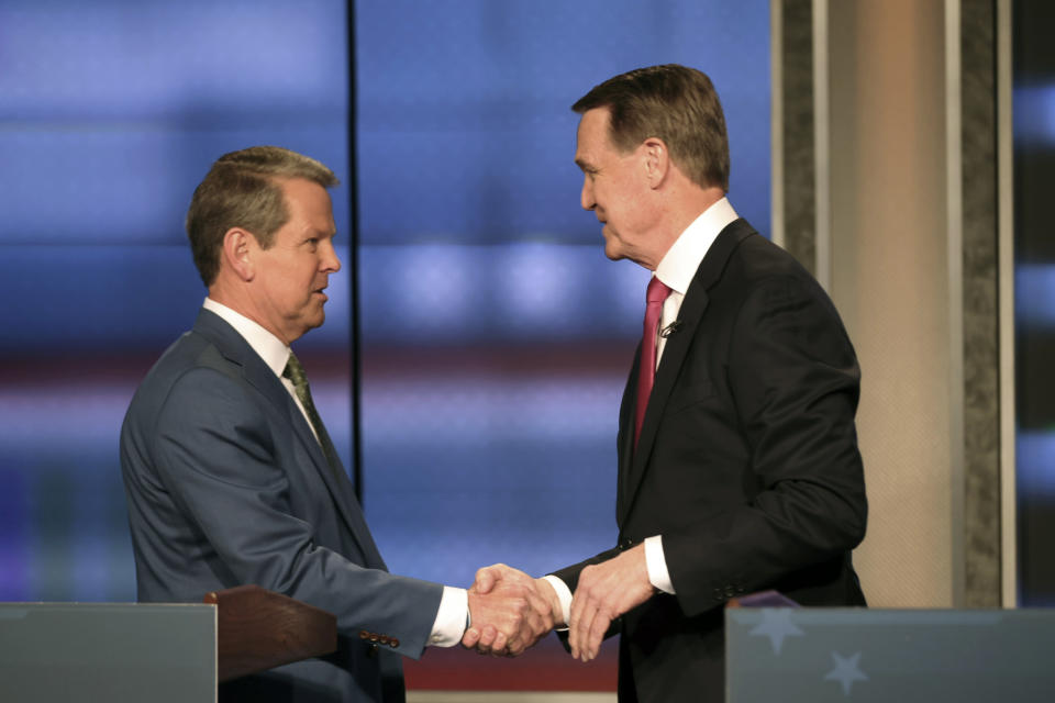 Georgia Gov. Brian Kemp, left, shakes hands with former Sen. David Perdue at a Republican gubernatorial debate, Sunday, April 24, 2022, in Atlanta. (Miguel Martinez/Atlanta Journal-Constitution via AP)