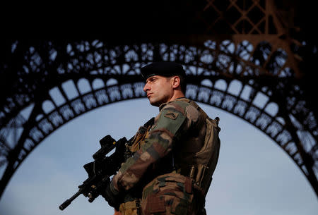FILE PHOTO: A French soldier stands guard under the Eiffel Tower, as France officially ended a state of emergency regime, replacing it with the introduction of a new security law, in Paris, France, November 1, 2017. REUTERS/Christian Hartmann