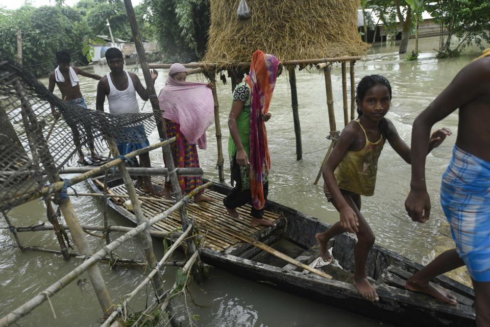 Villagers uses a boat to move across a flooded area in a flood effected village in Morigaon district of Assam in India on Friday, 17 July 2020. (Photo by David Talukdar/NurPhoto via Getty Images)