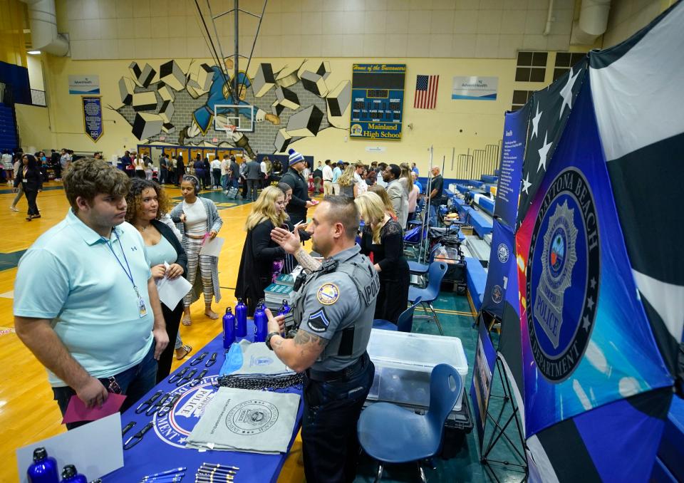 Mainland High School students speak with a representative from the Daytona Beach Police Department about job opportunities when they graduate next spring. The students participated in a career-college fair on Tuesday.