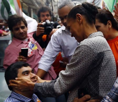 Presidential candidate Marina Silva of Brazilian Socialist Party (PSB) greets a man during a rally campaign at Rocinha slum in Rio de Janeiro August 30, 2014. REUTERS/Ricardo Moraes