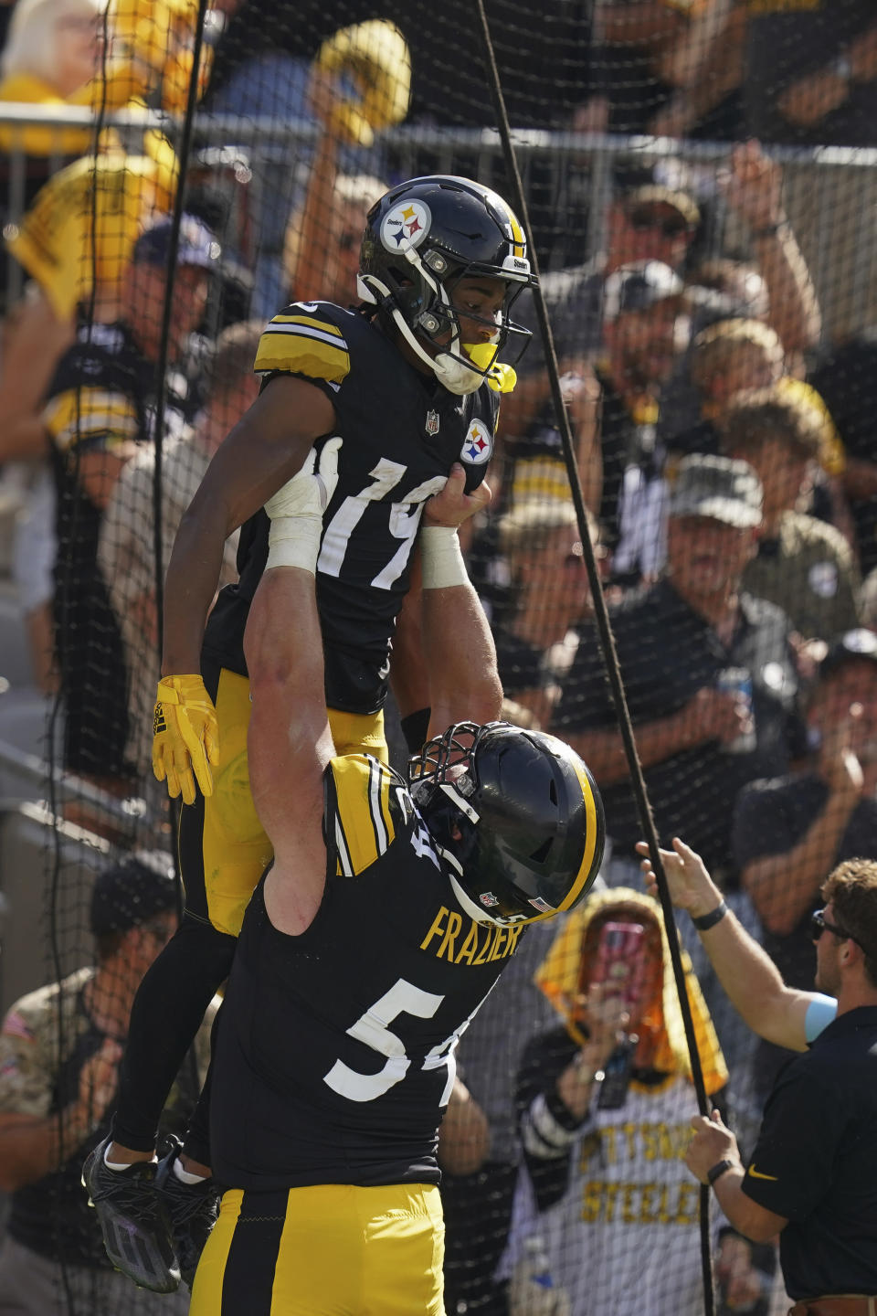 Pittsburgh Steelers wide receiver Calvin Austin III (19) is hoisted up by center Zach Frazier, bottom, after scoring a touchdown during the second half of an NFL football game against the Los Angeles Chargers, Sunday, Sept. 22, 2024, in Pittsburgh. (AP Photo/Matt Freed)