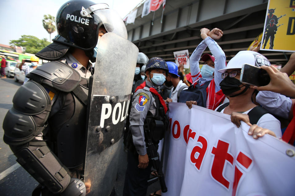 Anti-coup protesters stand face to face with riot police outside the Hledan Centre in Yangon, Myanmar Friday, Feb. 19, 2021. The daily protests campaigning for civil disobedience in Myanmar are increasingly focusing on businesses and government institutions that sustain the economy. (AP Photo)