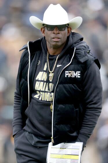 Colorado coach Deion Sanders watches as his team warms before playing their spring game