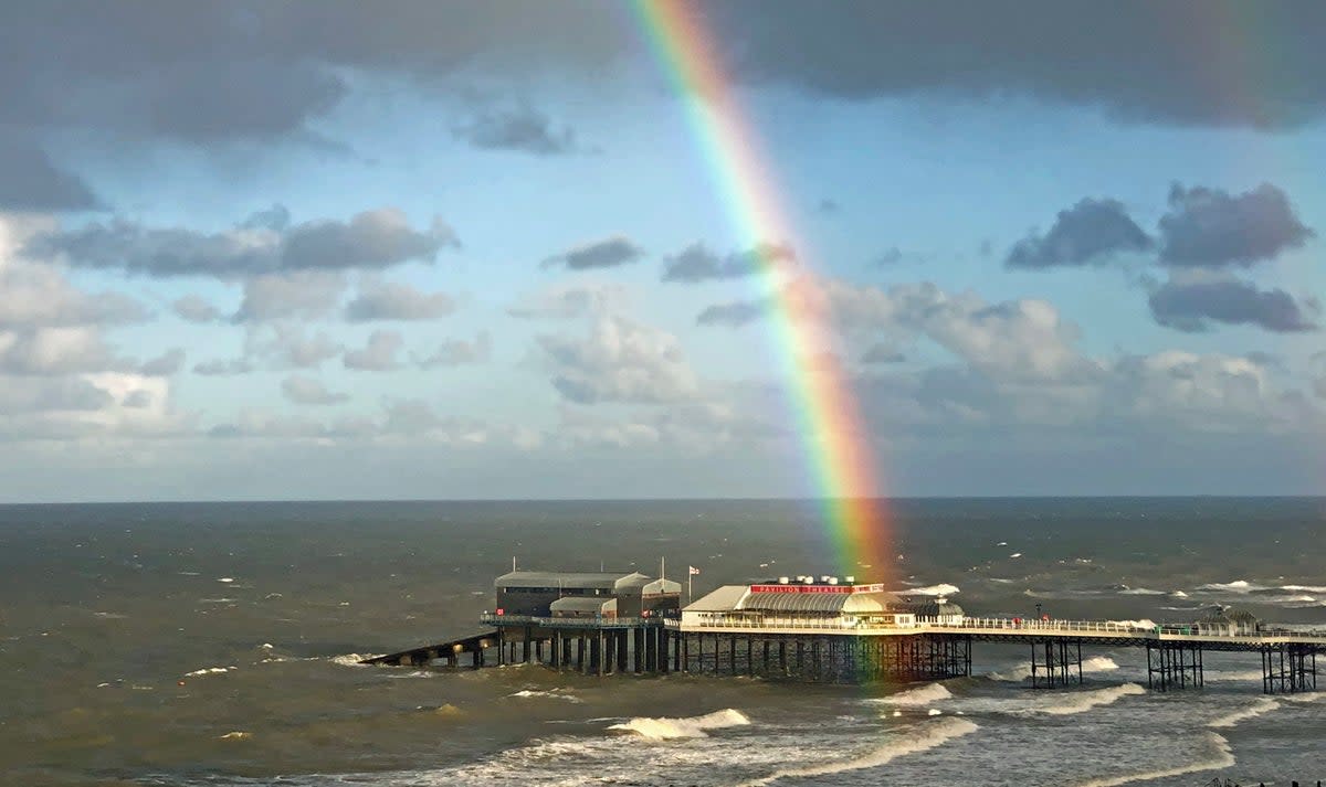 A rainbow is seen hanging over the pier in Cromer, Norfolk (Laura Kerr/PA) (PA Archive)