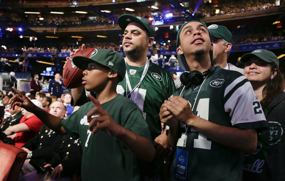 New York Jets fans listen for the Jets' fourth-round selection at the 2014 NFL Draft, Saturday, May 10, 2014, in New York. The Jets picked Oklahoma wide receiver Jalen Saunders. (AP Photo/Julie Jacobson)