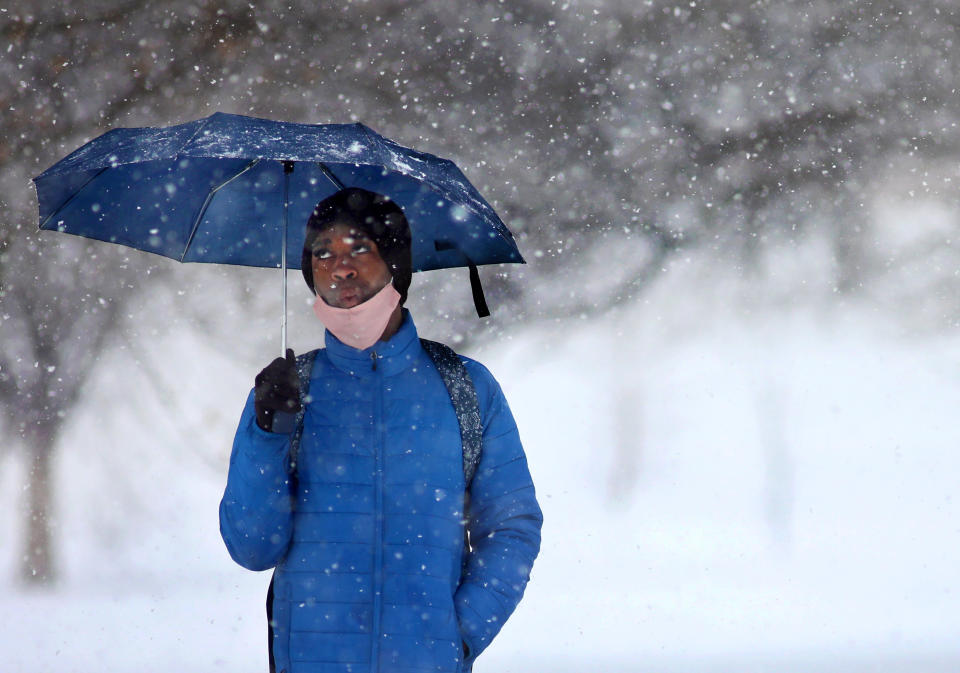 "I'm happy to have snow, but this much is overwhelming," says Malik Marmon as he waits to take the bus to work along North Grand Boulevard and Natural Bridge Avenue in St. Louis, on Wednesday, Feb. 17, 2021. A brief snowstorm hit St. Louis on Wednesday morning after a storm, Monday dropped nearly nine inches in some places across the region. (Colter Peterson/St. Louis Post-Dispatch via AP)