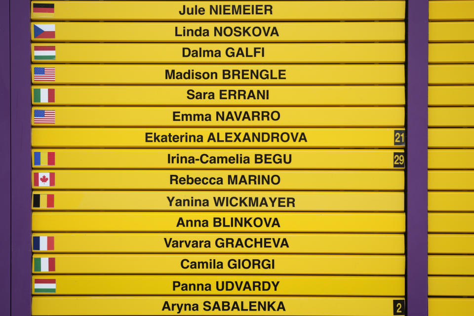 Part of a scoreboard showing players names and their flags with Russian and Belarus flags omitted, on day one of the Wimbledon tennis championships in London, Monday, July 3, 2023. Players from Russia and Belarus are back after being banned by the All England Club a year ago over the war in Ukraine. (AP Photo/Alastair Grant)